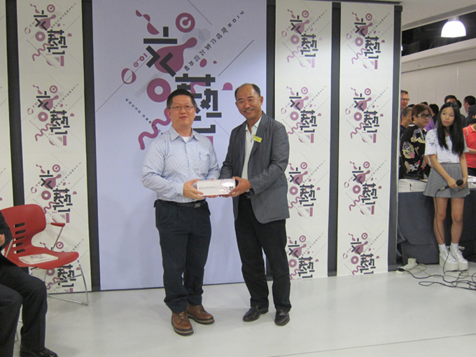 Father Chan, the chairman of school management committee of C01 School of Visual Arts, give the souvenir to the representative of e-print